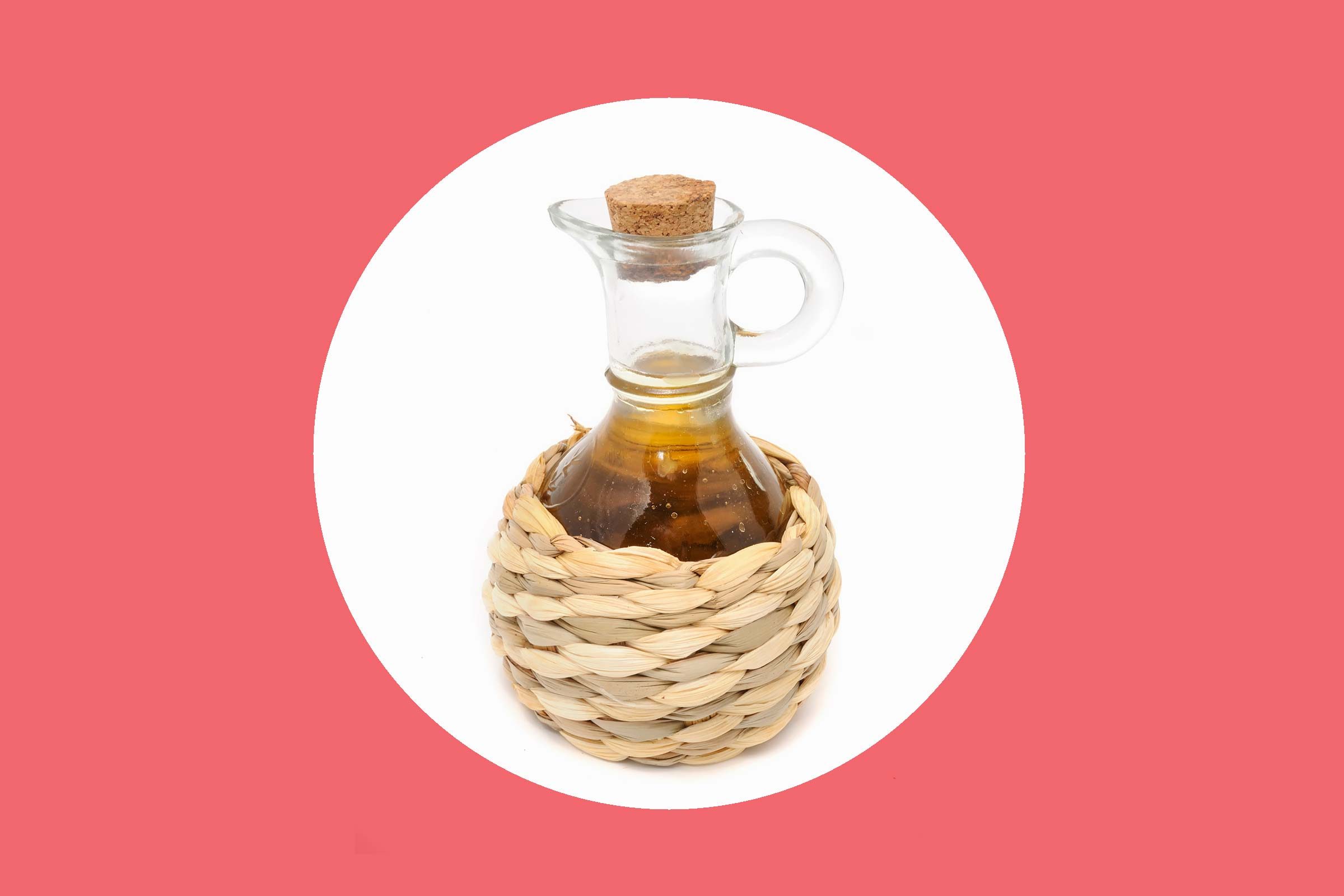 apple cider vinegar in a straw-bottomed glass pourer