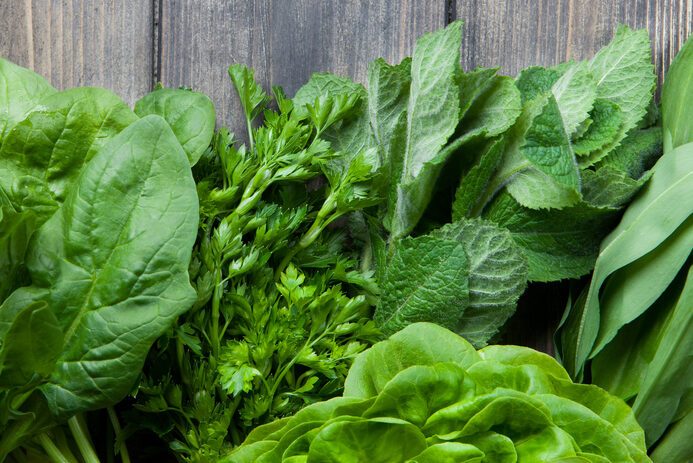 Fresh herbs (dill, parsley, spinach, peppermint, wild garlic) on a wood background. Ð¢op view. Copy space.