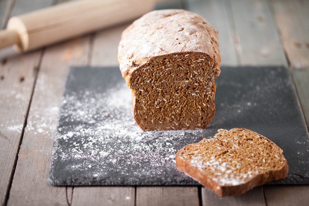 Fresh Irish soda bread with oat sliced on a slate cutting board.