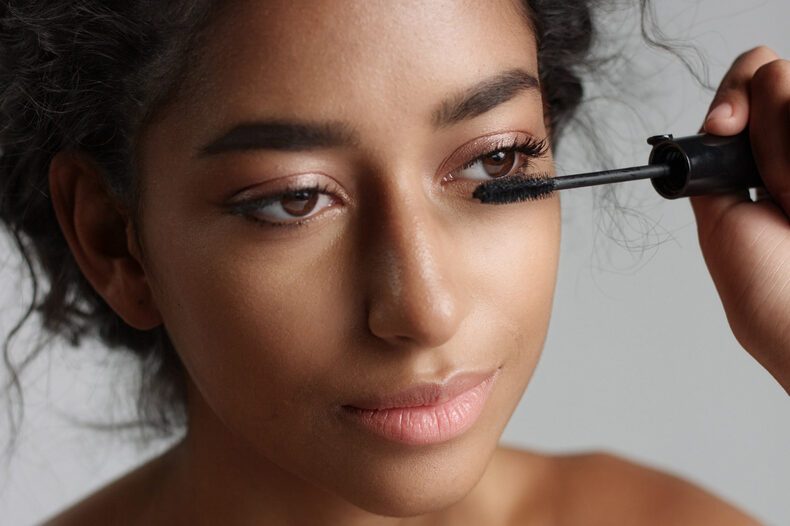 Teenage Middle Eastern girl applying mascara to her lashes