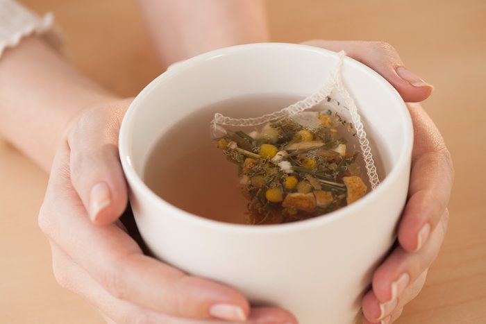 hands holding a mug of chamomile tea