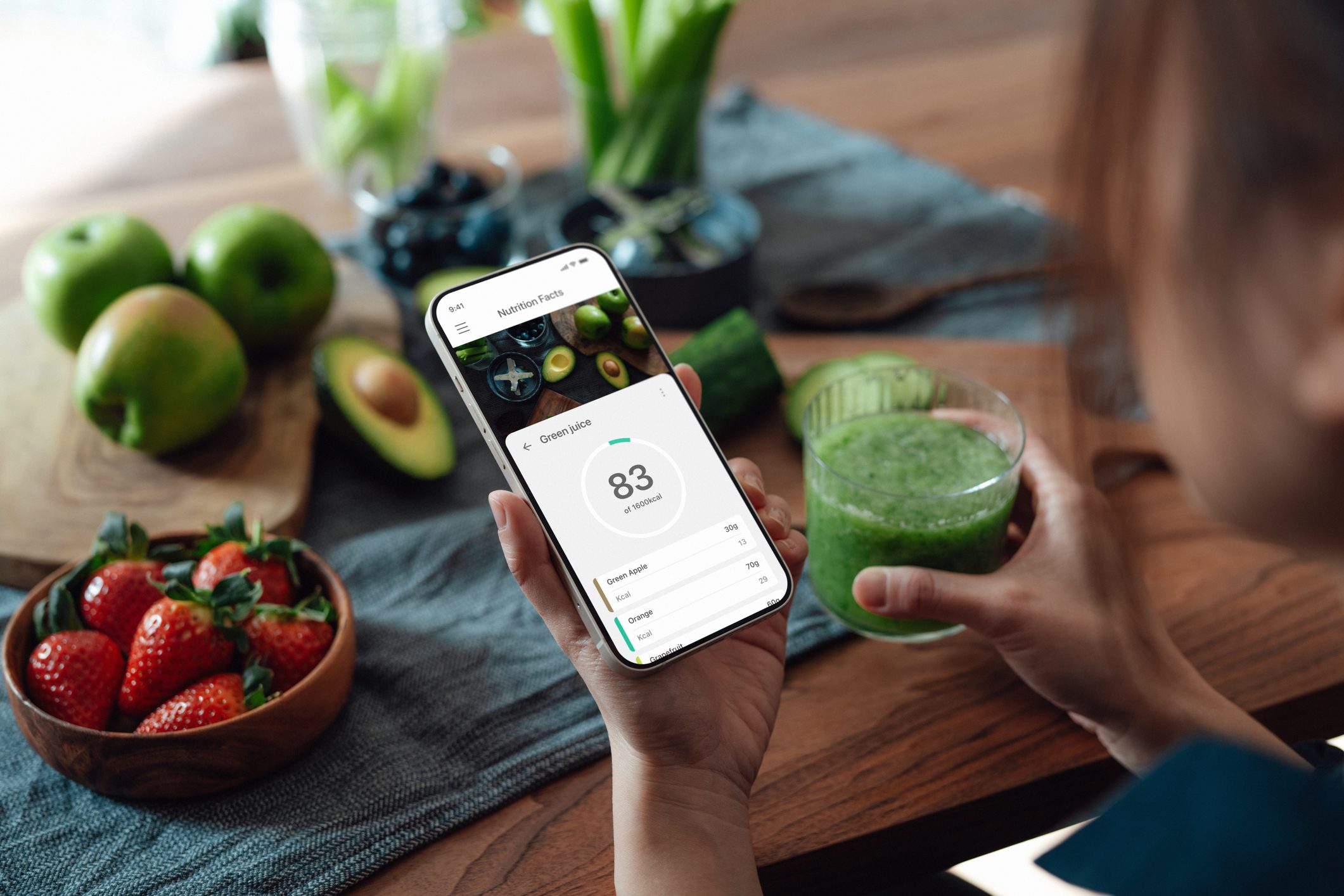 Young woman checking nutrition facts and calories intake of her meal with meal planning app on smartphone